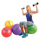 A woman sits on a set of colorful exercise balls, smiling while engaging in a fitness routine.